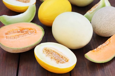 Photo of Different types of tasty ripe melons on wooden table