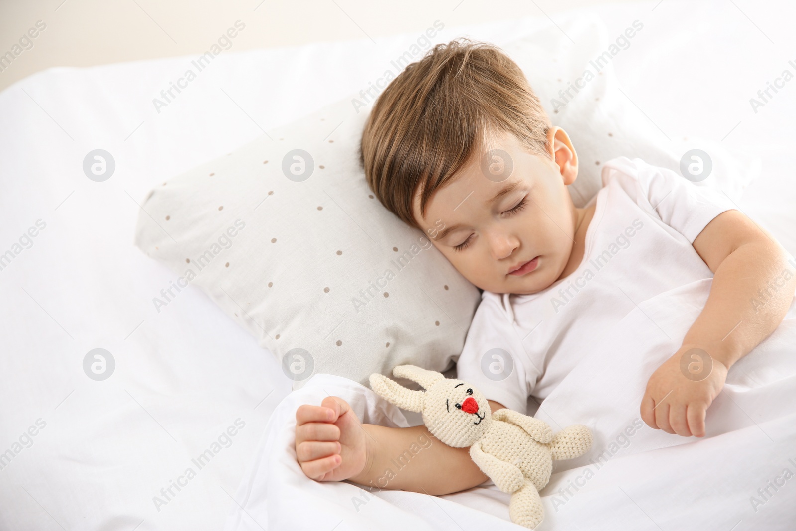 Photo of Cute little baby sleeping with toy at home. Bedtime