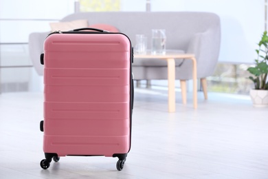 Photo of Stylish modern suitcase indoors, space for text