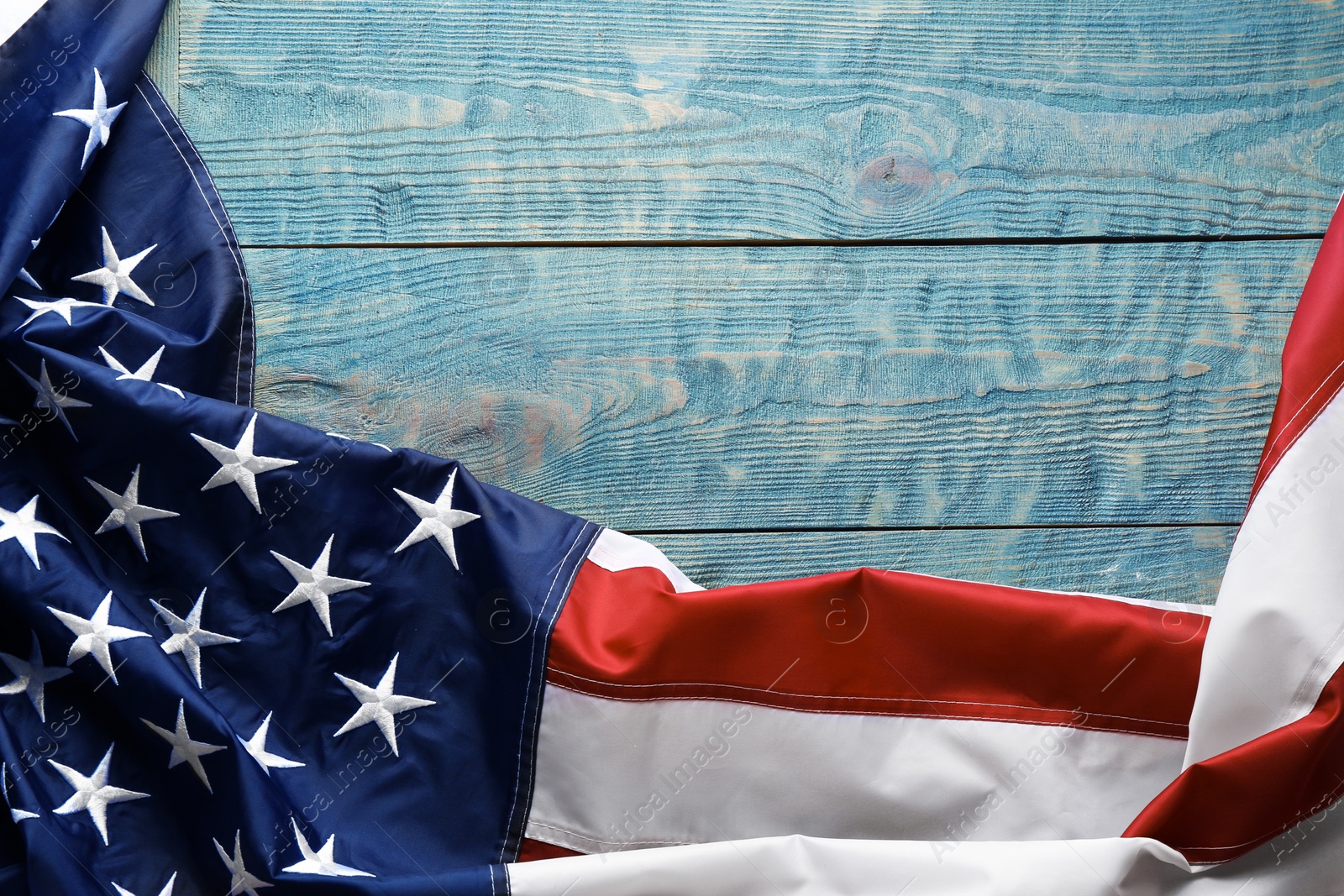 Photo of American flag on wooden background, top view with space for text