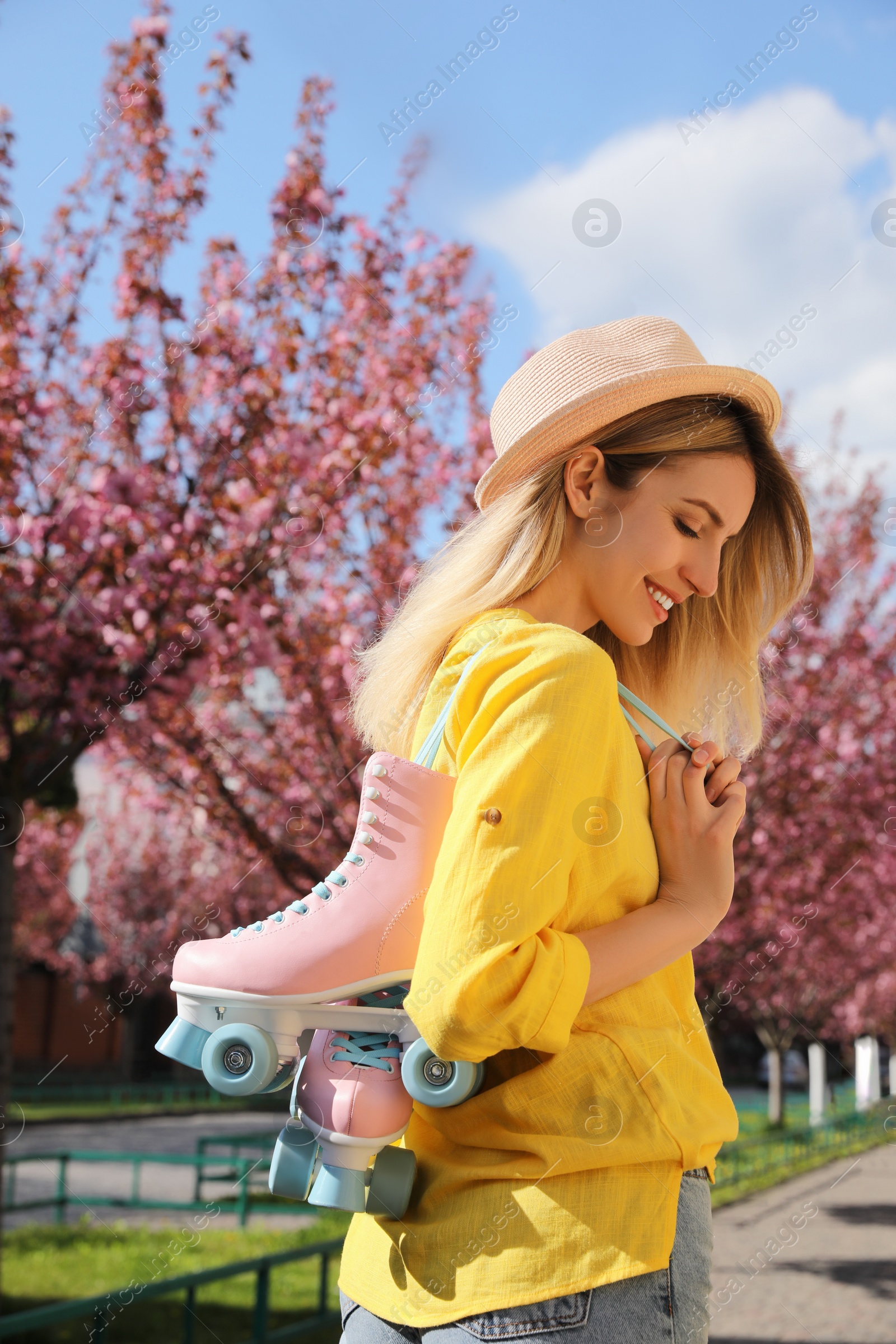 Photo of Young woman with roller skates in spring park