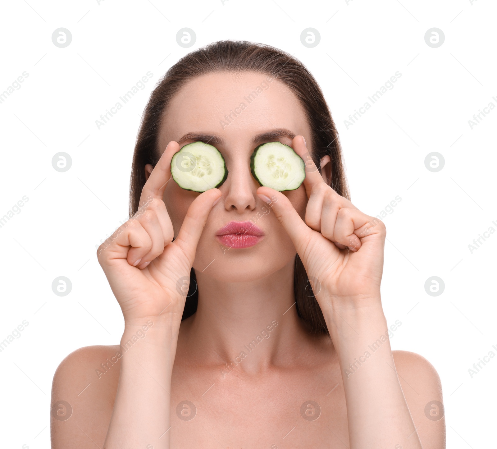 Photo of Beautiful woman covering eyes with pieces of cucumber and blowing kiss on white background