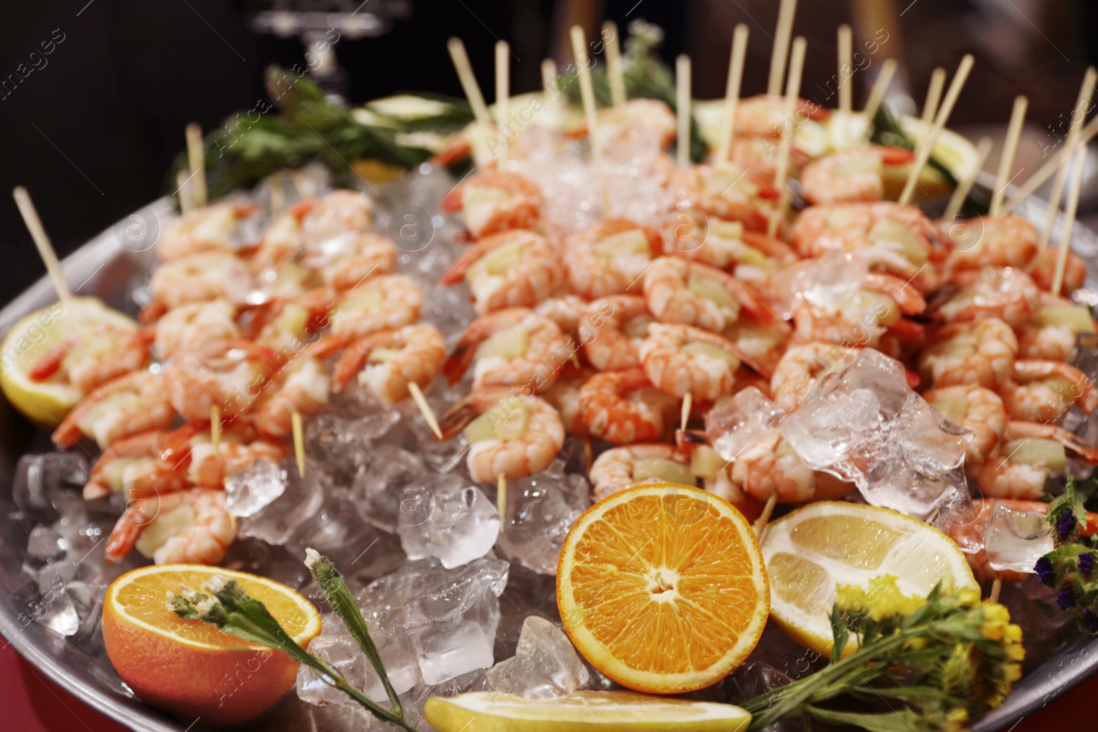 Photo of Shrimp skewers served in dish with ice, closeup