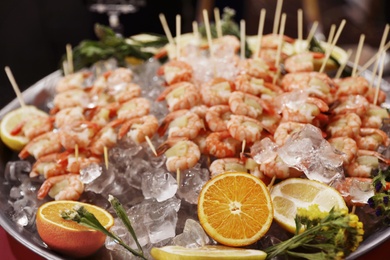 Photo of Shrimp skewers served in dish with ice, closeup