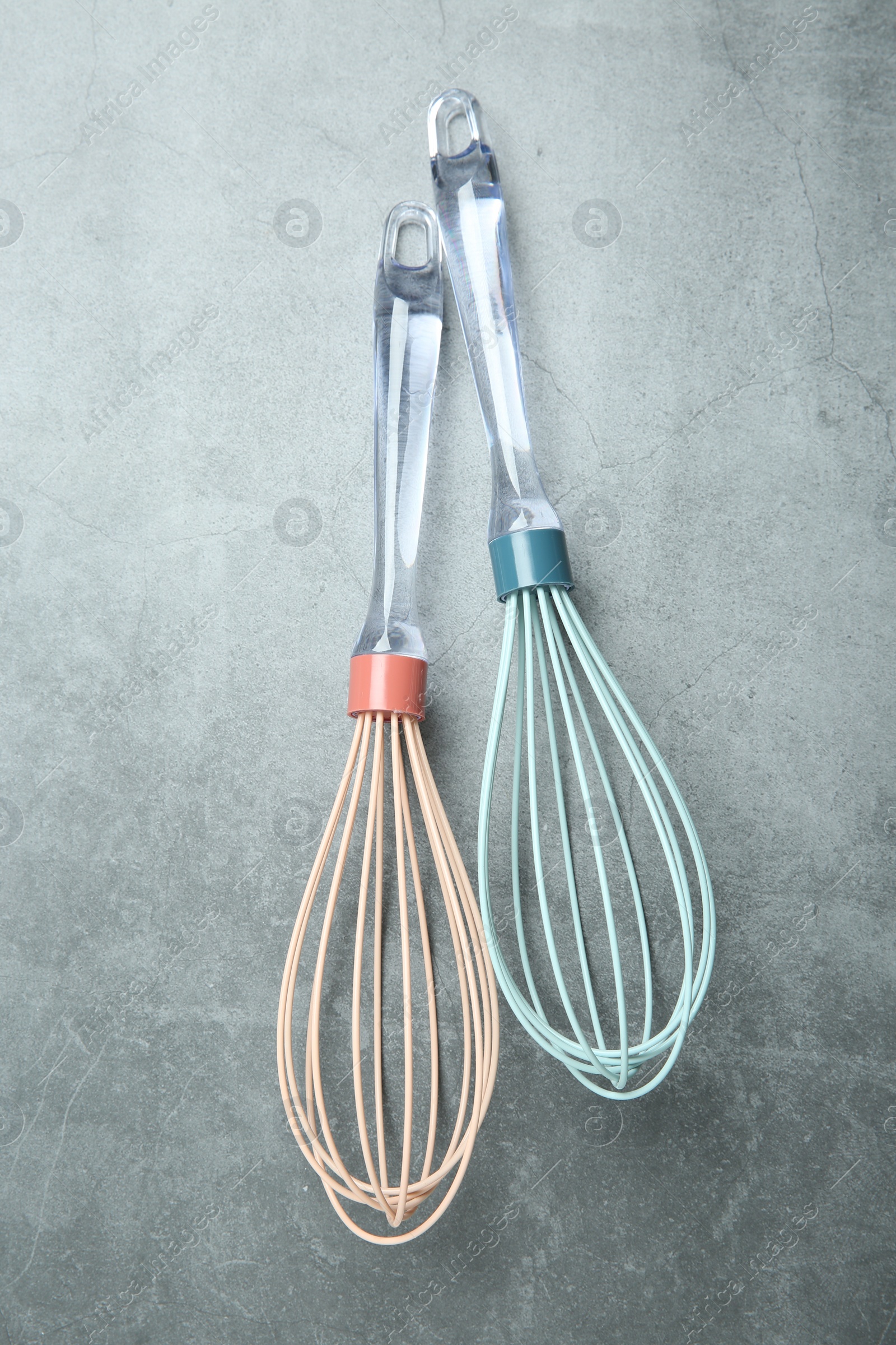 Photo of Two whisks on gray table, top view