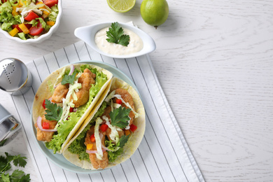 Photo of Yummy fish tacos served on white wooden table, flat lay. Space for text