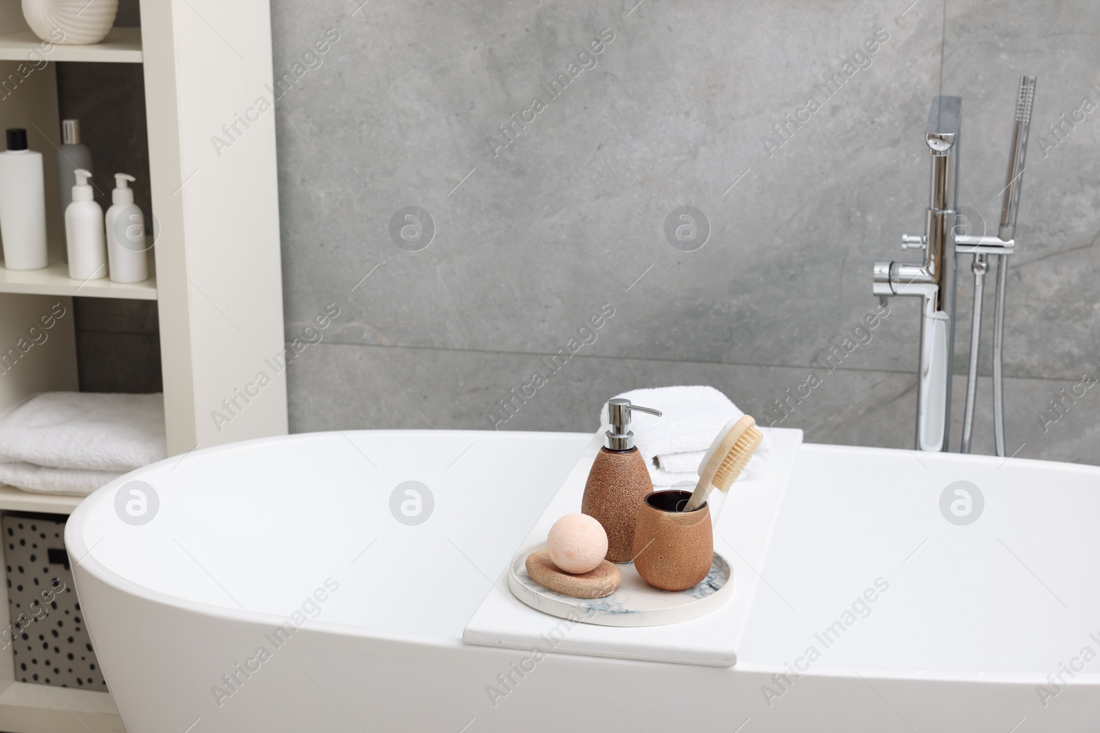 Photo of Different personal care products and accessories on bath tub in bathroom