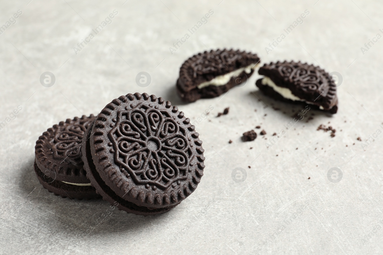 Photo of Tasty chocolate cookies with cream on grey background. Space for text