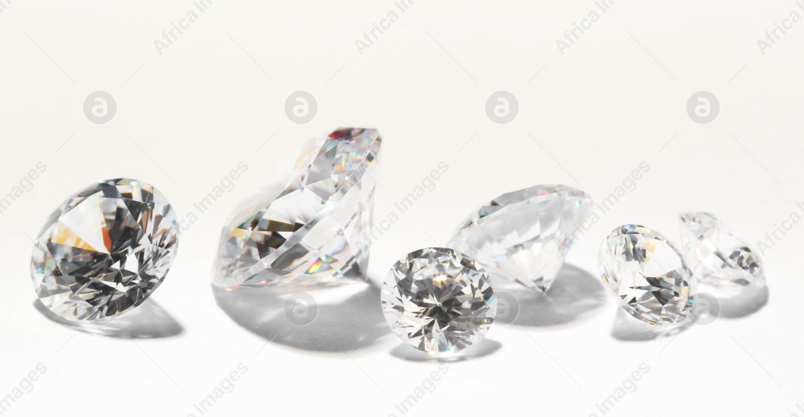 Photo of Many beautiful shiny diamonds on white background