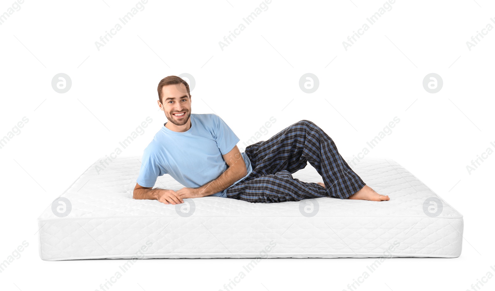 Photo of Young man lying on mattress against white background