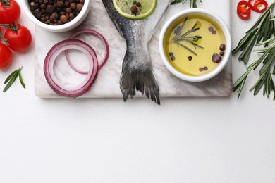 Photo of Fresh dorado fish and ingredients on white table, flat lay. Space for text