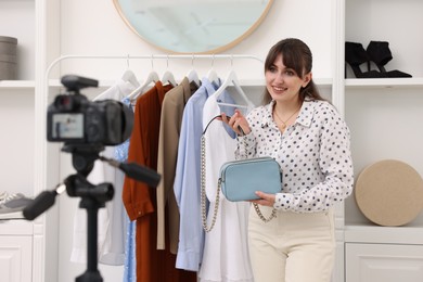 Smiling fashion blogger showing her clothes while recording video at home