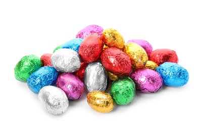 Many chocolate eggs wrapped in bright foil on white background