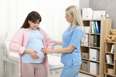 Photo of Happy pregnant woman having doctor appointment in hospital