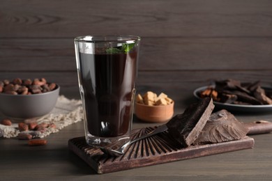 Photo of Glass of delicious hot chocolate on wooden table