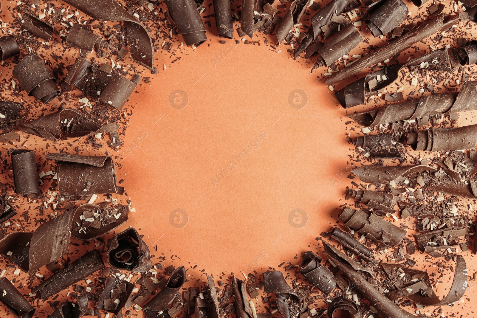 Photo of Flat lay composition with chocolate curls and space for text on color background