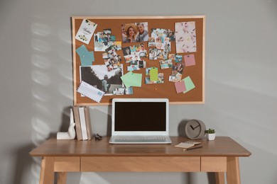 Photo of Stylish workplace with vision board and laptop