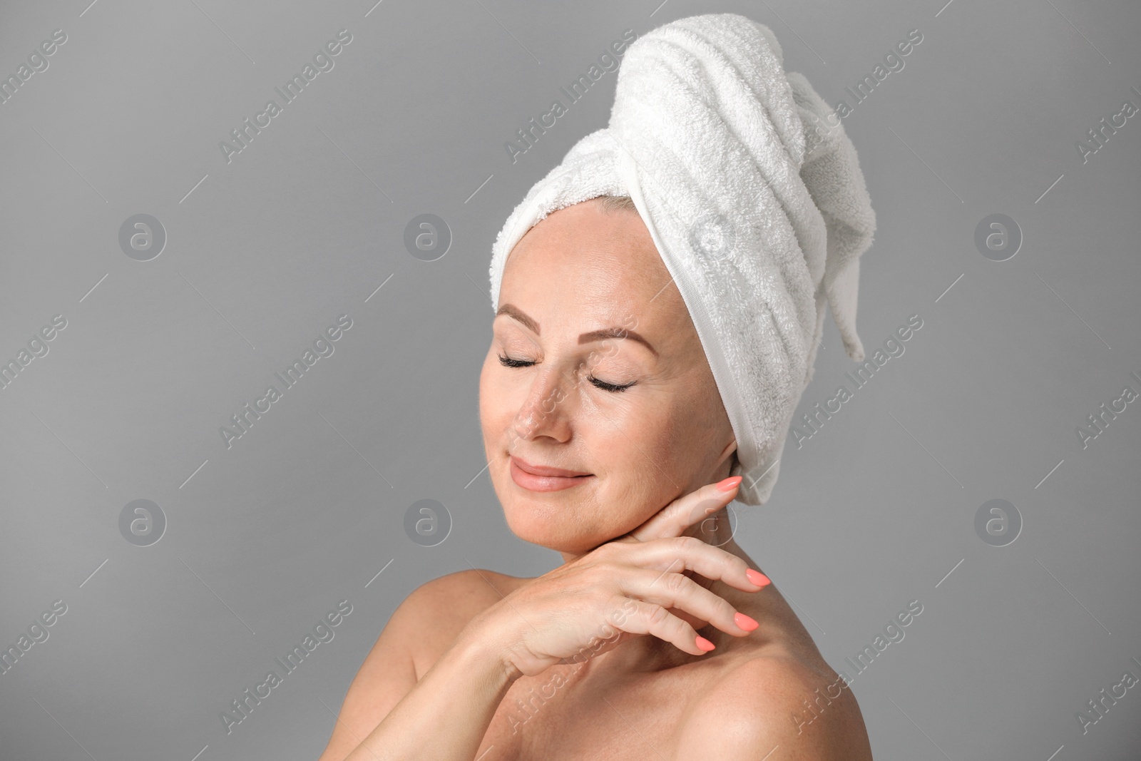 Photo of Portrait of beautiful mature woman with perfect skin on grey background