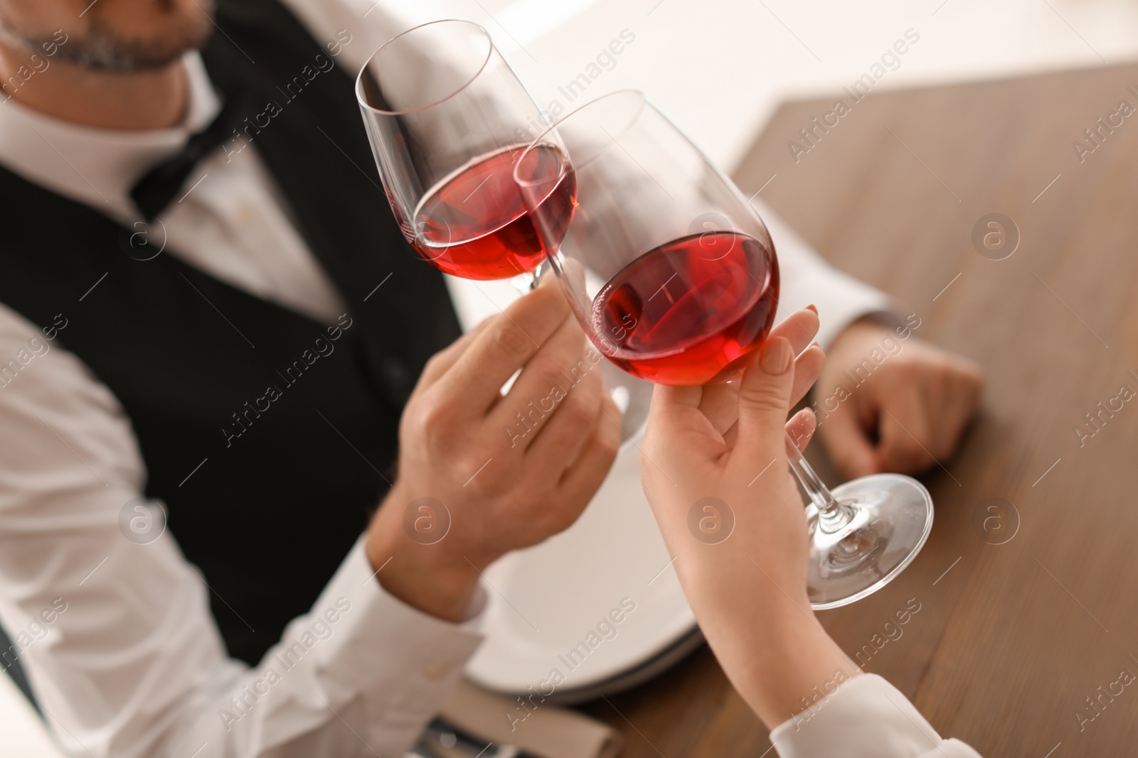 Photo of Young couple with glasses of delicious wine in restaurant