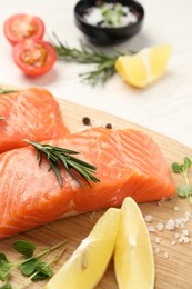 Photo of Fresh salmon and ingredients for marinade on wooden board, closeup