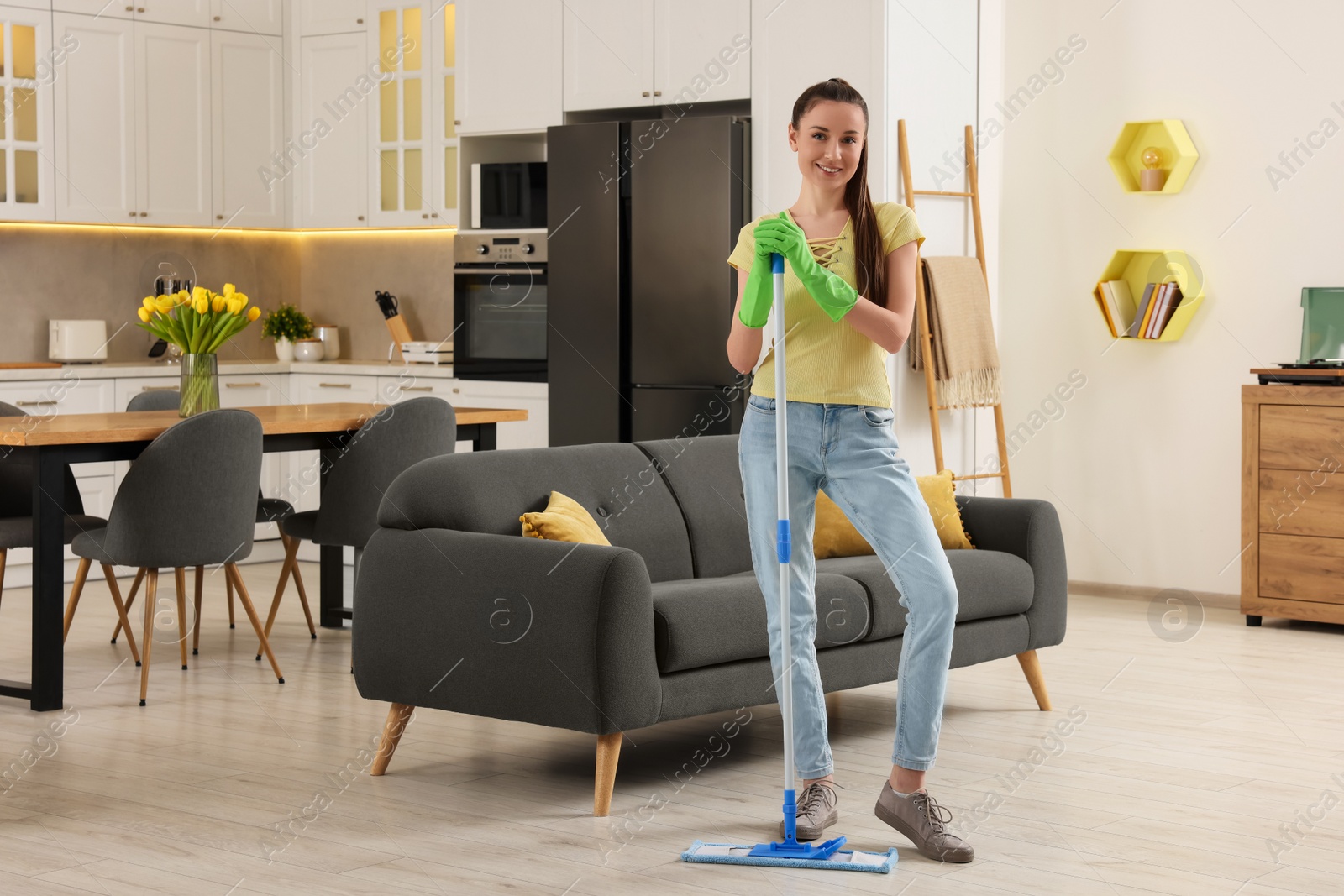 Photo of Spring cleaning. Young woman with mop washing floor at home