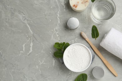 Flat lay composition with tooth powder and mint on light grey marble table, space for text