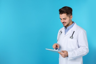 Photo of Young medical student with tablet on color background. Space for text