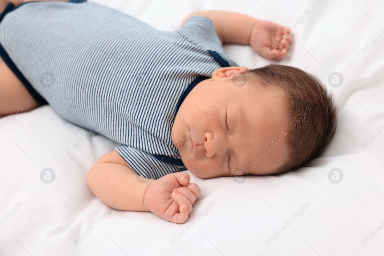 Photo of Cute newborn baby sleeping on white soft bed