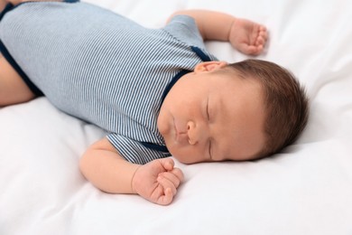 Cute newborn baby sleeping on white soft bed