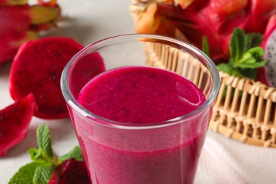 Photo of Delicious pitahaya smoothie and fresh fruits on table, closeup