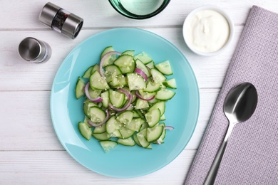 Flat lay composition with delicious fresh cucumber onion salad on table