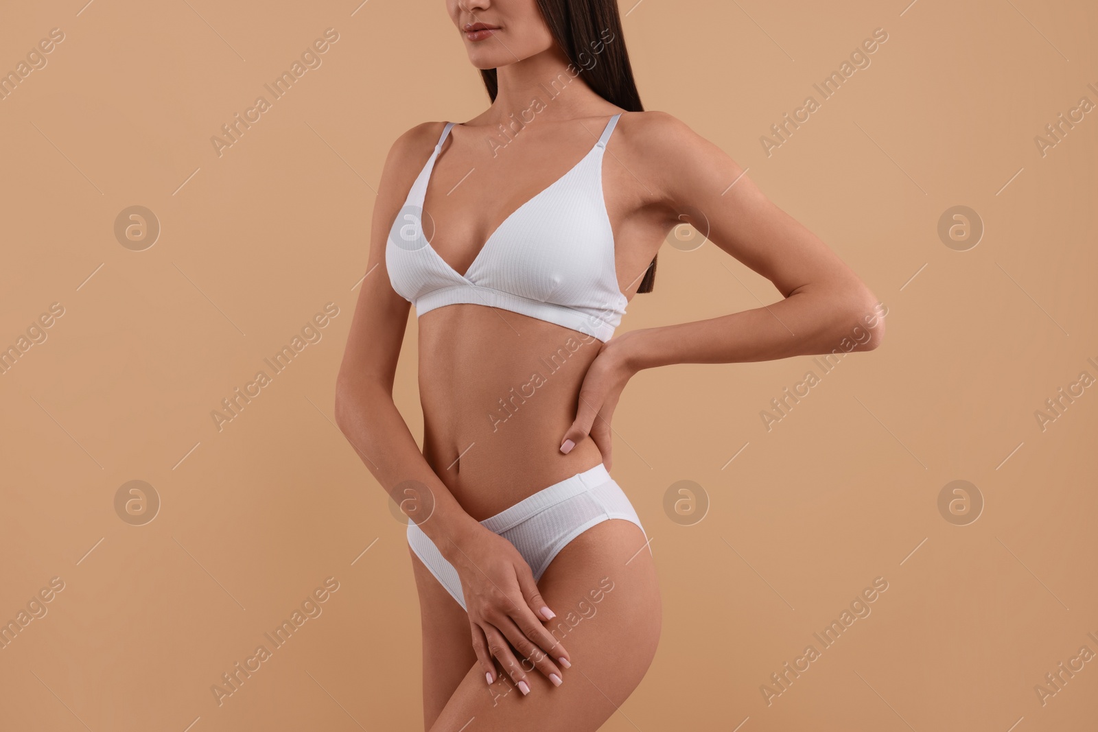 Photo of Young woman in stylish white bikini on beige background, closeup