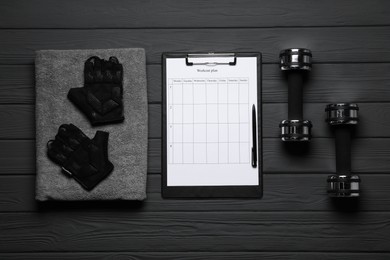 Photo of Workout plan, pen and sports equipment on black wooden table, flat lay . Personal training