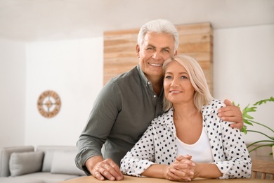 Photo of Portrait of affectionate senior couple at home. Space for text