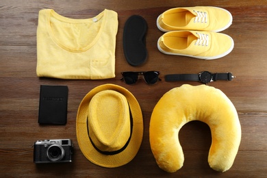 Photo of Flat lay composition with travel pillow and tourist stuff on wooden background