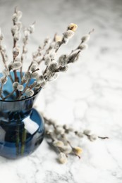 Photo of Beautiful pussy willow branches on white marble table, closeup