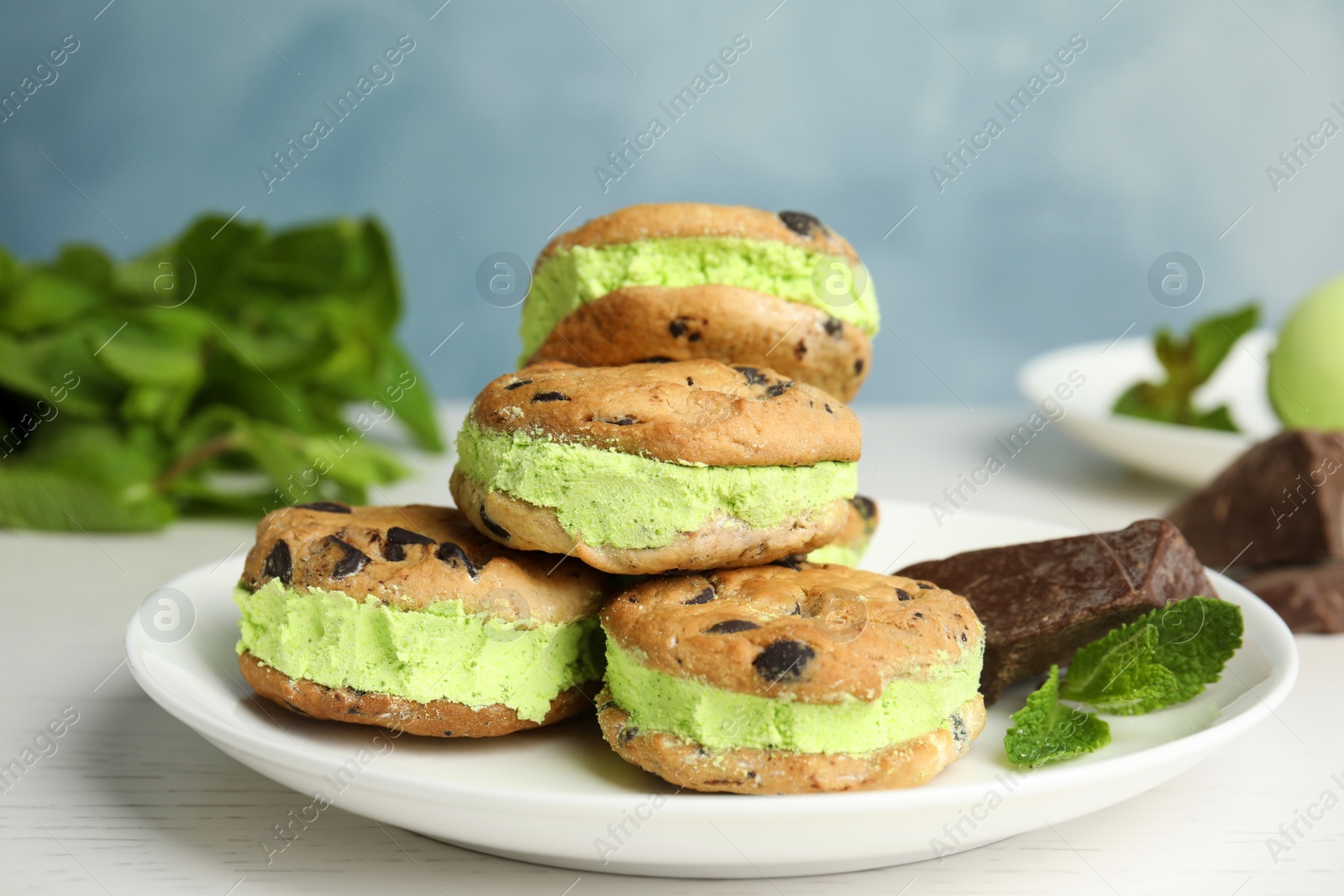 Photo of Plate with sweet delicious ice cream cookie sandwiches on table