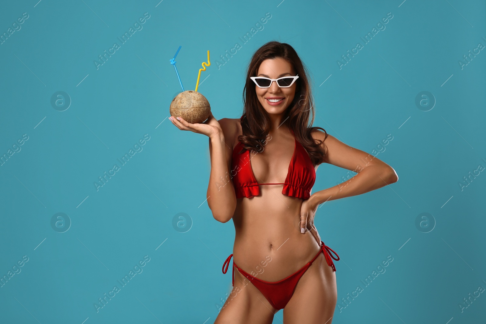 Photo of Beautiful woman in stylish bikini with tropical cocktail on blue background