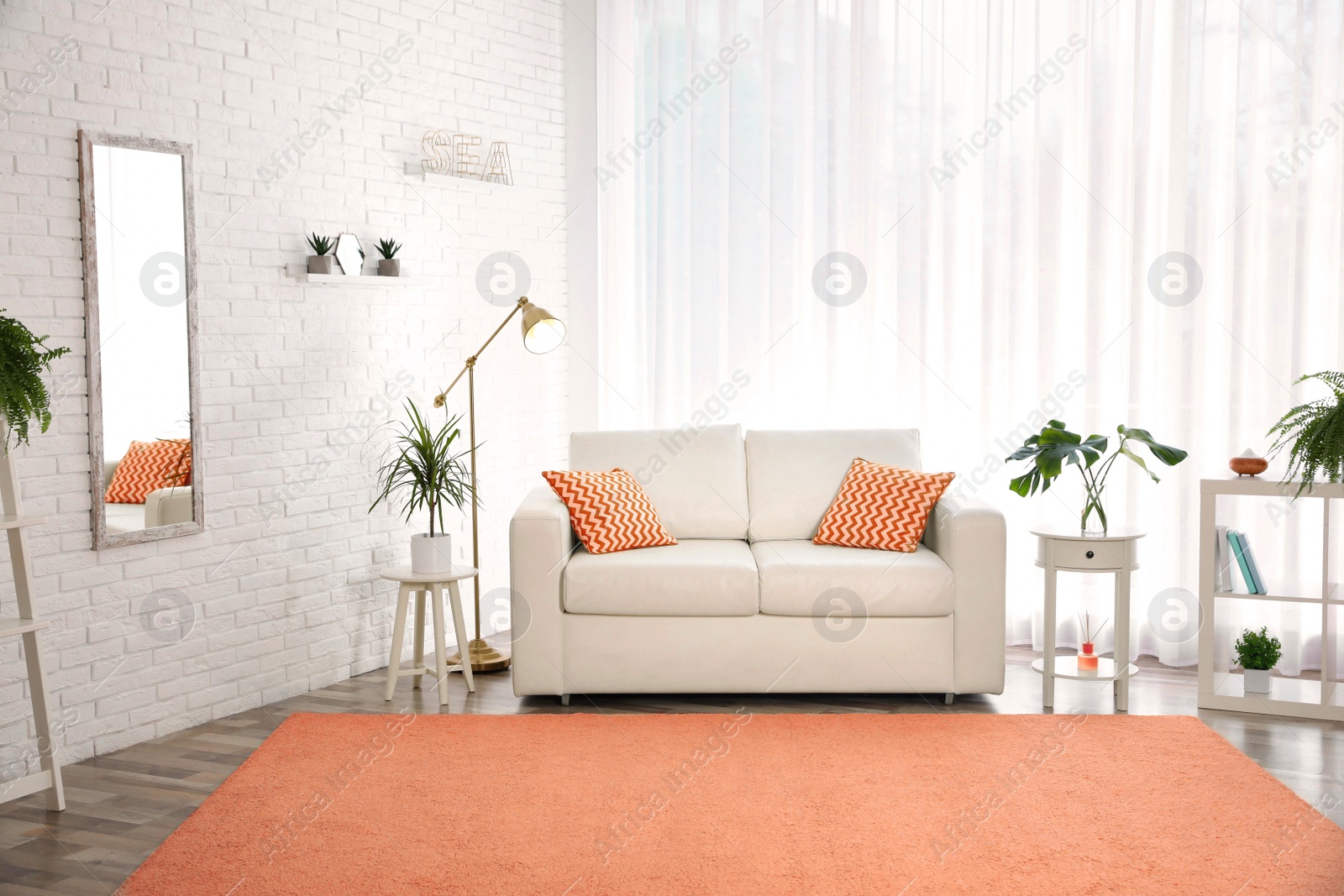 Image of Stylish room interior with comfortable sofa and orange carpet