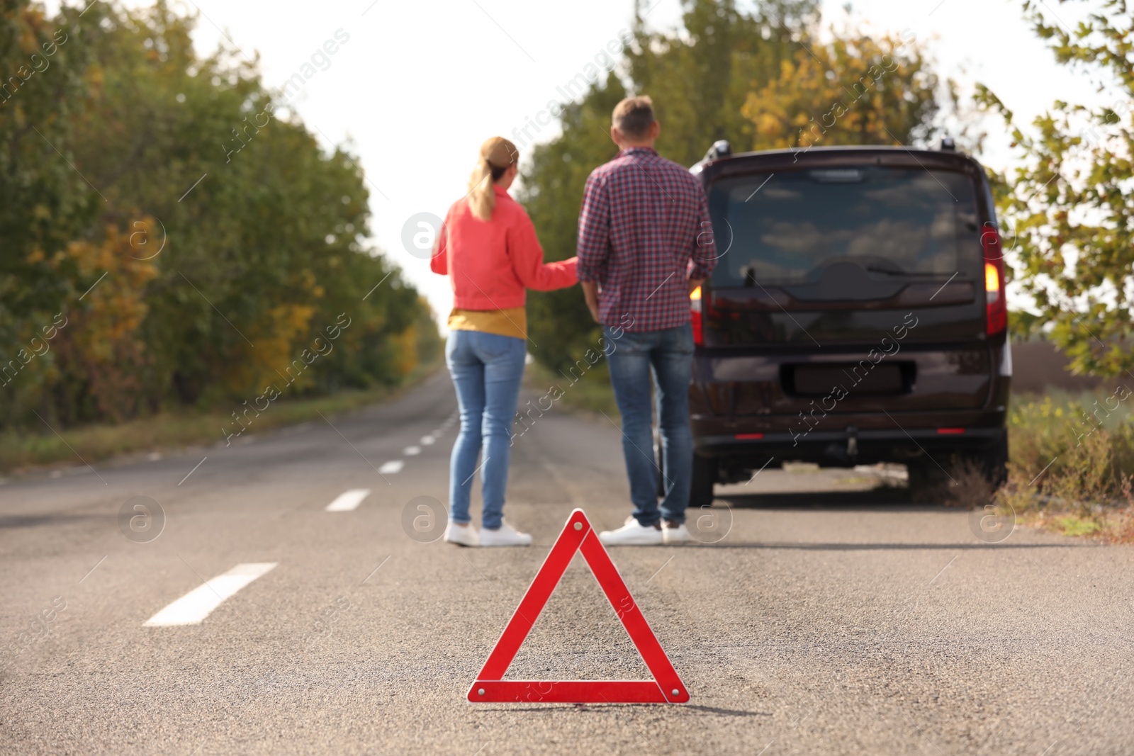 Photo of Emergency stop sign near people discussing car accident on road. Auto insurance