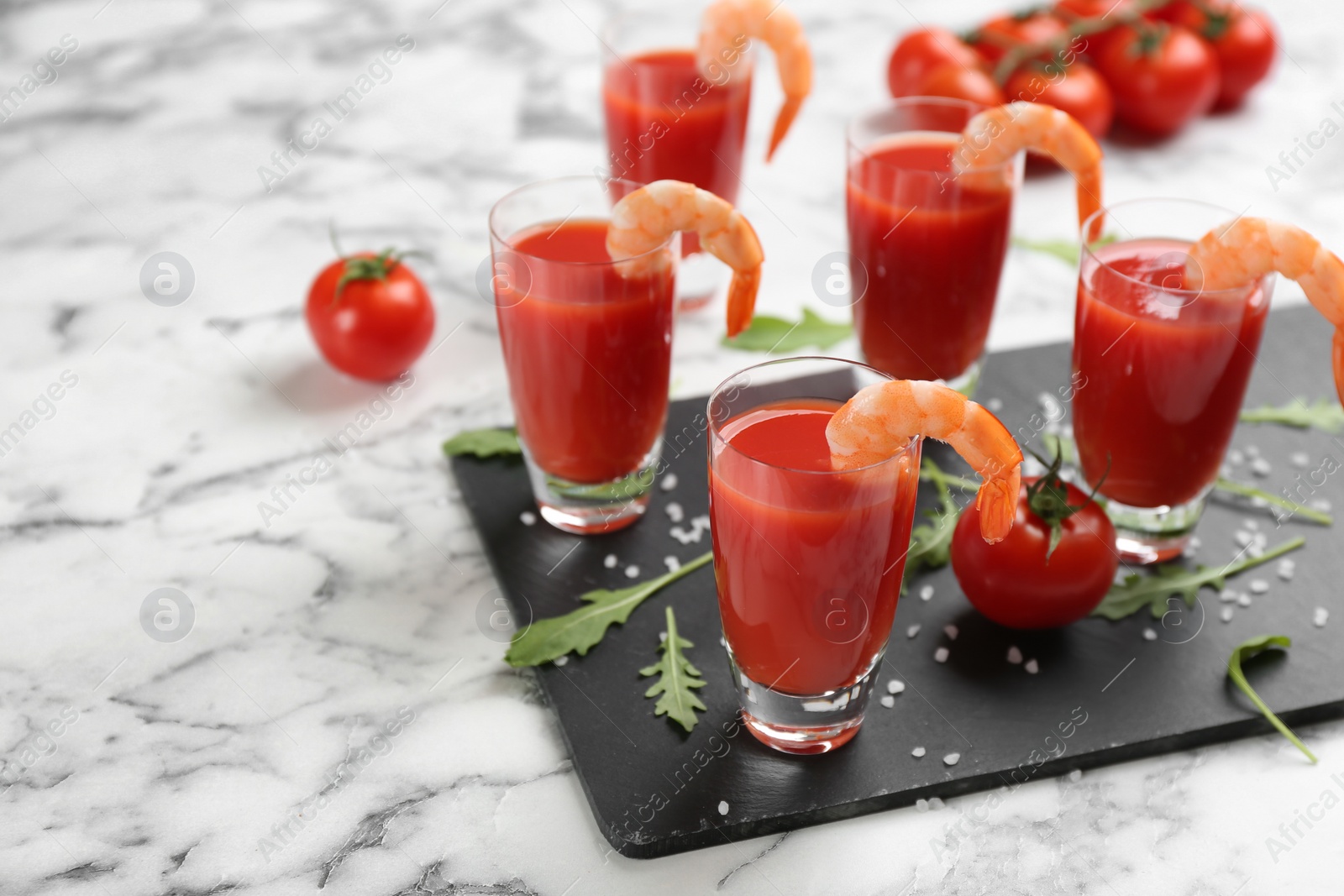 Photo of Shrimp cocktail with tomato sauce served on marble table