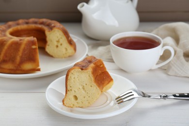 Piece of delicious homemade yogurt cake served on white wooden table