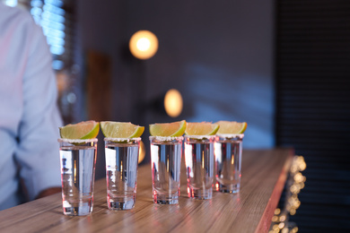 Photo of Mexican Tequila shots with salt and lime slices on bar counter