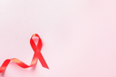 Photo of Red ribbon on color background, top view. Cancer awareness