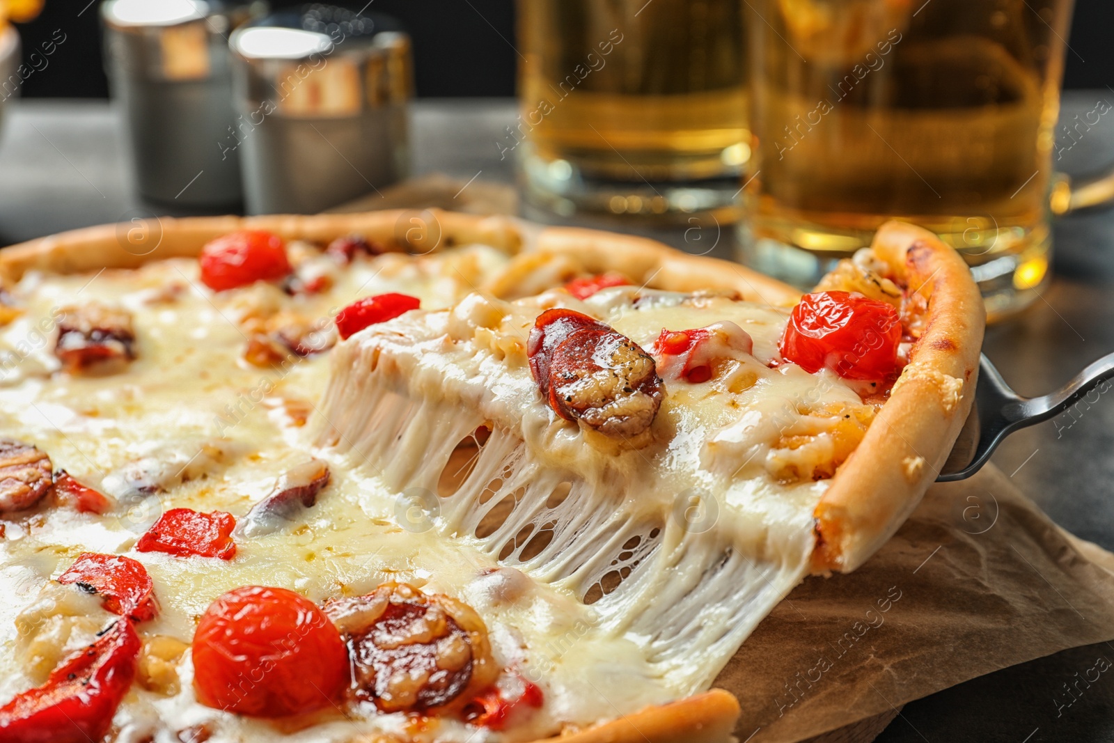 Photo of Shovel with slice of delicious hot pizza over table, closeup