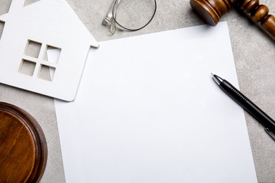 Photo of Last will and testament near house figure, glasses and gavel on light grey table, flat lay