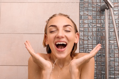 Photo of Beautiful young woman taking shower at home