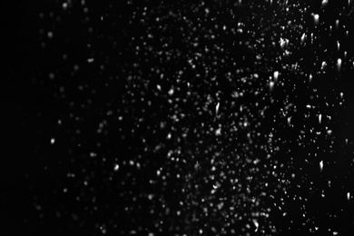 Photo of Snow flakes falling on black background. Winter weather