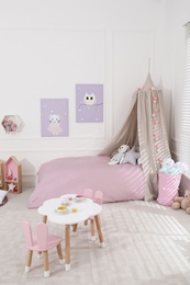 Photo of Cute child's room interior with toys and modern furniture