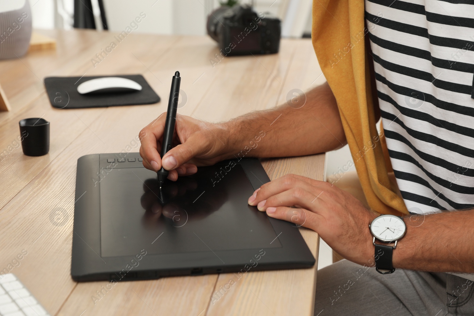 Photo of Professional retoucher working on graphic tablet at desk, closeup